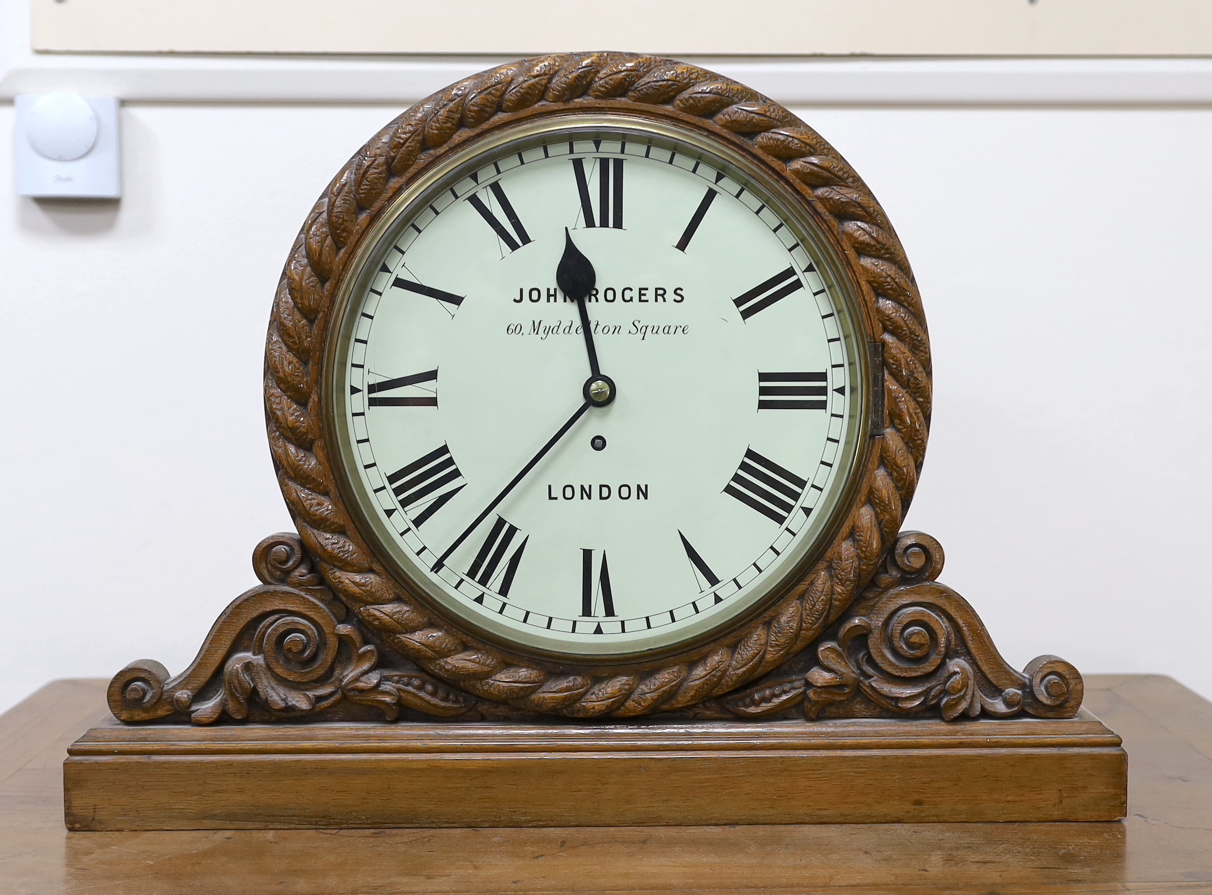 A Victorian carved oak mantel timepiece with fusee movement, signed John Rogers of London, 62cm wide